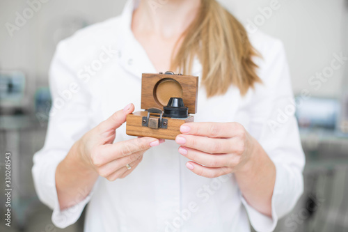 Doctor ophthalmologist surgeon holds Indirect Ophthalmoscopy Lens which used in ophthalmic practice for the general diagnosis of eye diseases and specifically for Selective Laser Trabeculoplasty photo