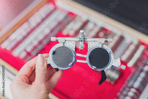 Optometrist trial frame in front of Ophthalmic Test Lens Kit. A universal messy tool for optometrists and optometrists. A set of diopter glasses for vision correction. photo