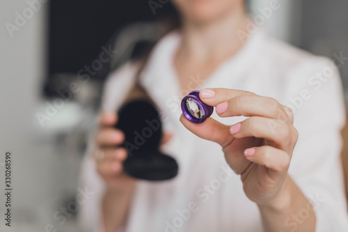 Ophthalmologist surgeon holds in his hands Indirect Ophthalmoscopy Lens which is used in ophthalmic for the general diagnosis of eye diseases and specifically for Selective Laser Trabeculoplasty