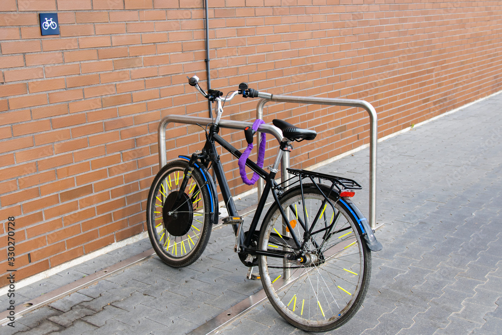 Bike parked in a special parking lot near a brick wall.