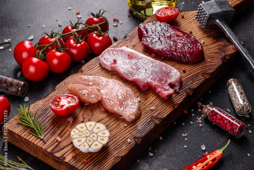 Fresh juicy steak of beef, pork and chicken with vegetables ready to cook
