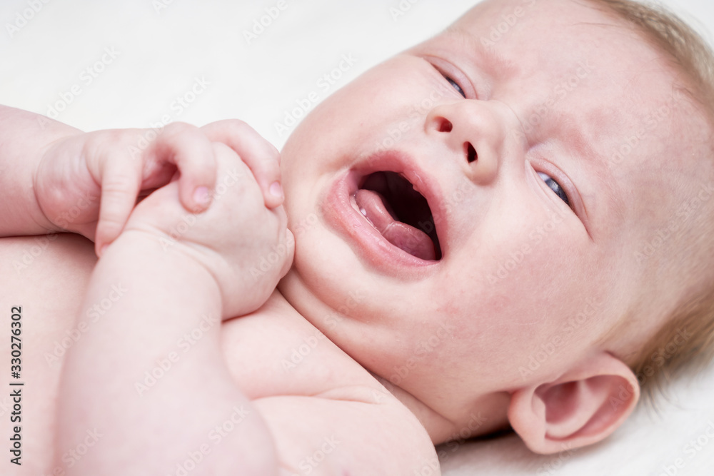 Cute crying baby on a light background Close up. Cute crying baby on a light background Close up.