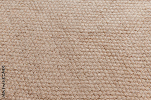 Beige wool knitted fabric with texture. Handwork.