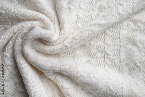 White wool knitted fabric texture. Wrinkled twisted fabric background.