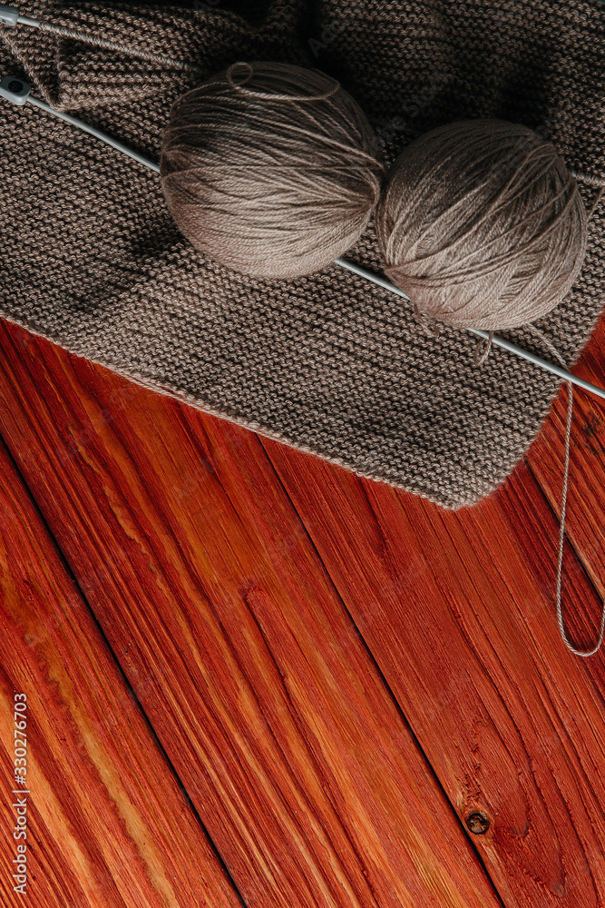Winter needlework. Balls of wool yarn for hand knitting and knitting spokes on a wooden background. Text space Flat layout, large plan, top view, copy of space Winter needlework. Balls of wool yarn for hand knitting and knitting spokes on a wooden background. Text space Flat layout, large plan, top view, copy of space