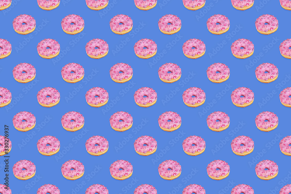Fashionable seamless pattern of traditional doughnuts with lilac glaze on trendy classic blue background. Regular rhythmic pattern. Top view, flat lay. Horizontal orientation. Fashionable seamless pattern of traditional doughnuts with lilac glaze on trendy classic blue background. Regular rhythmic pattern. Top view, flat lay. Horizontal orientation.