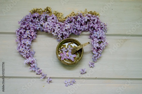 Heart of lilac flowers on a wooden gray table. flowers lilac