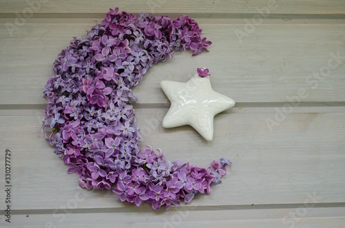 month created from lilac flowers on a wooden gray table. flowers lilac crescent