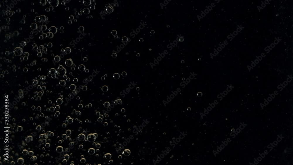 Air bubbles floating up in water on black background. Air bubbles floating up in water on black background.