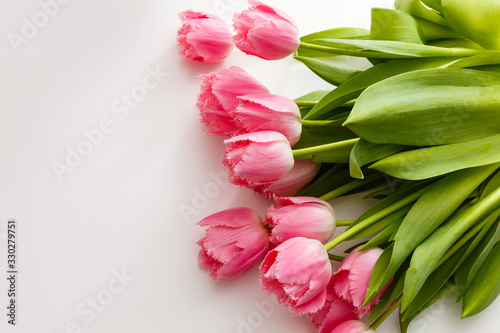 Fototapeta Naklejka Na Ścianę i Meble -  pink tulips lie on a white table