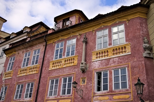 Old bohemian building with yellow balconies and a red wall (Prague, Czech Republic, Europe)
