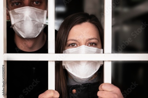 A woman in a mask , looking intently at the camera. Quarantine and isolation of patients with covid coronavirus 2019. Isolation grid, incarceration and illness. pandemics and epidemics, photo