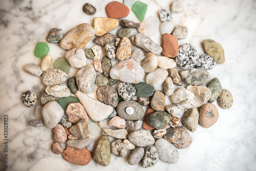 many sea colored stones, sea stones on marble, composition of rocks, composition of sea stones, sea stones on marble slab, 