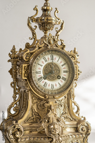 dial of vintage bronze watch , antique clock photo close up, old bronze clock in gilding, front of bronze fireplace clock, eight o'clock on the dial , 8 pm  on the dial of the old clock