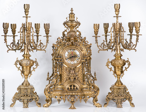 Vintage gold watch with candelabra on white background, bronze clock and candelabra, gold candlesticks and clock, antique clock and candlesticks, vintage clock with chandeliers on a white background