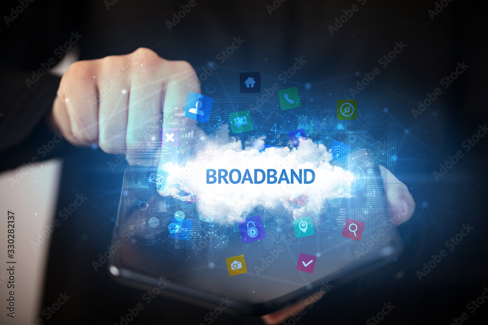 Fototapeta premium Businessman holding a foldable smartphone with BROADBAND inscription, technology concept