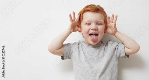 Redhead child and boy being silly and having fun in front of camera, showing silly face and emotions  photo