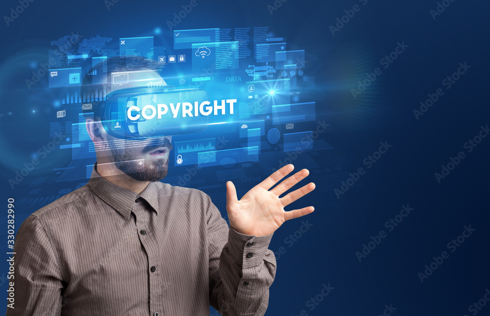 Businessman looking through Virtual Reality glasses with COPYRIGHT inscription, innovative security concept Businessman looking through Virtual Reality glasses with COPYRIGHT inscription, innovative security concept