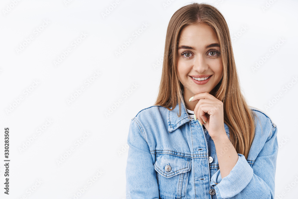 Beauty, fashion and lifestyle concept. Good-looking blond female looking at camera with lovely smile, touch chin, shopping online thinking what order, waiting delivery, white background Beauty, fashion and lifestyle concept. Good-looking blond female looking at camera with lovely smile, touch chin, shopping online thinking what order, waiting delivery, white background
