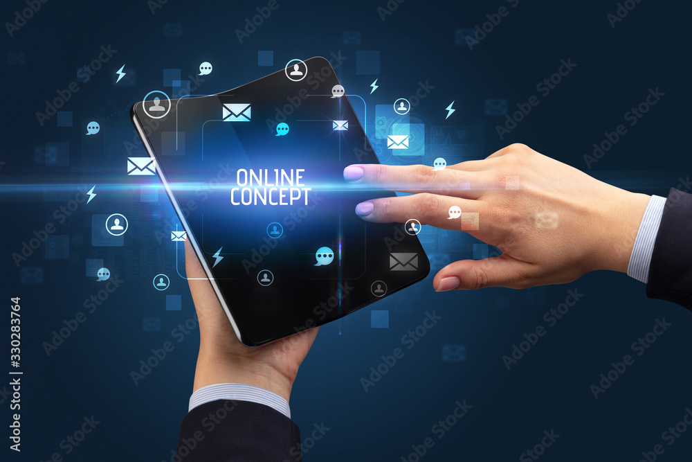 Businessman holding a foldable smartphone with ONLINE CONCEPT inscription, social networking concept Businessman holding a foldable smartphone with ONLINE CONCEPT inscription, social networking concept