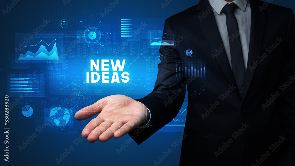 Hand of Businessman holding NEW IDEAS inscription, business success concept