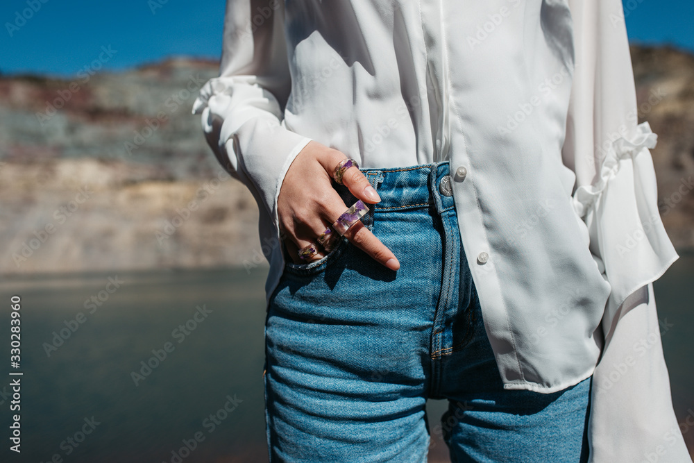 Close up photo of unrecognisable model hand wearing few purple handmade floral rings- beauty and jewellery concept. Close up photo of unrecognisable model hand wearing few purple handmade floral rings- beauty and jewellery concept.