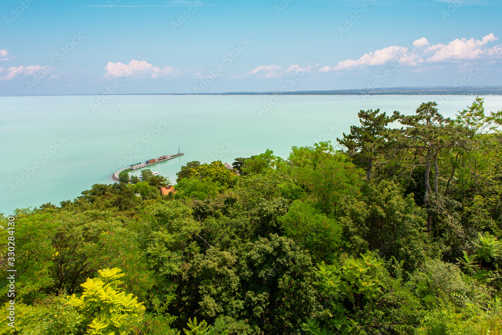 Lake Balaton with Tihany port and lots of green foliage in the foreground.