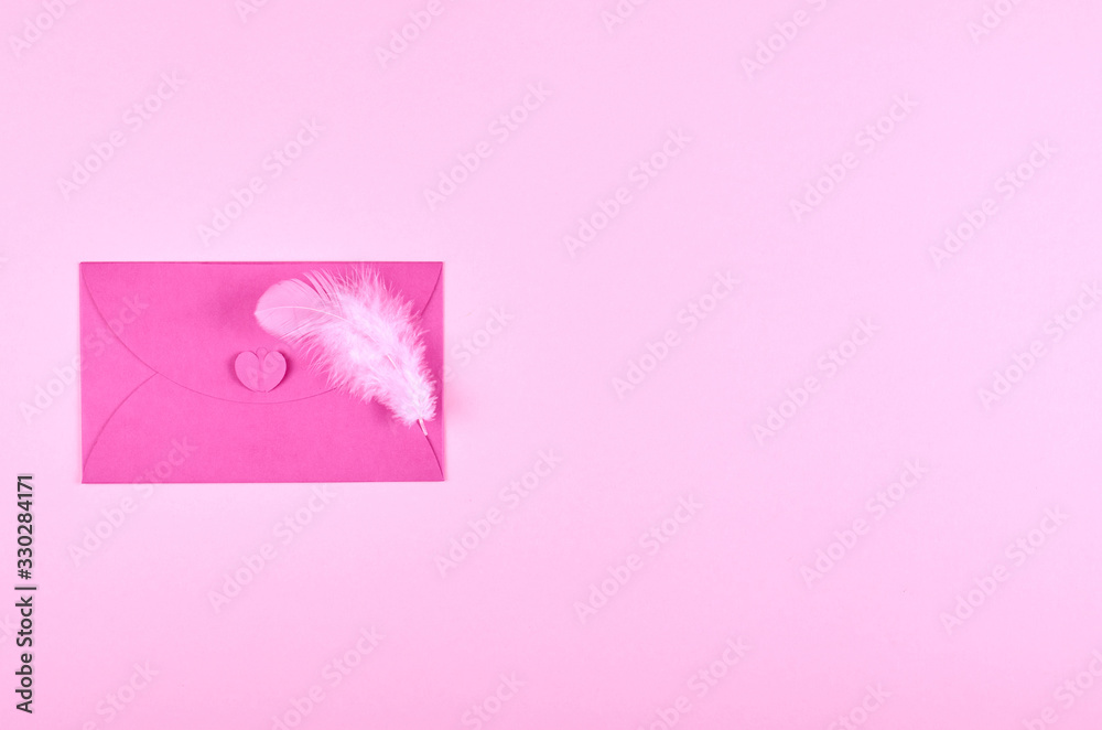 Envelope and feather on pink background composition.