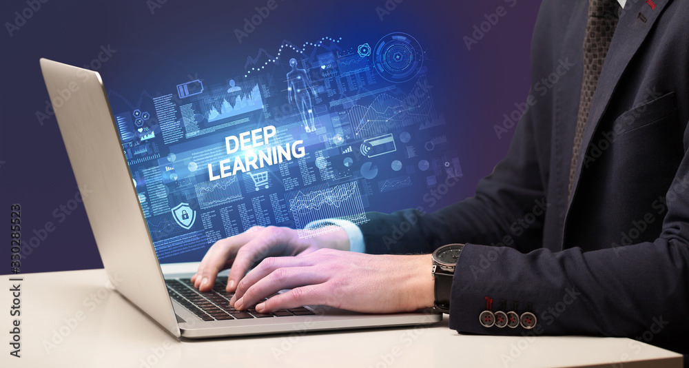 Businessman working on laptop with DEEP LEARNING inscription, cyber technology concept