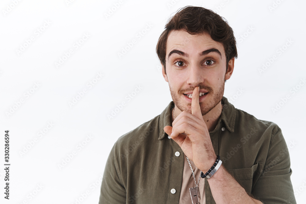 Cute bearded guy in casual outfit asking keep secret safe, shush be quiet with index finger pressed to lip, smiling happy and friendly, please stay silent gesture, standing white background Cute bearded guy in casual outfit asking keep secret safe, shush be quiet with index finger pressed to lip, smiling happy and friendly, please stay silent gesture, standing white background