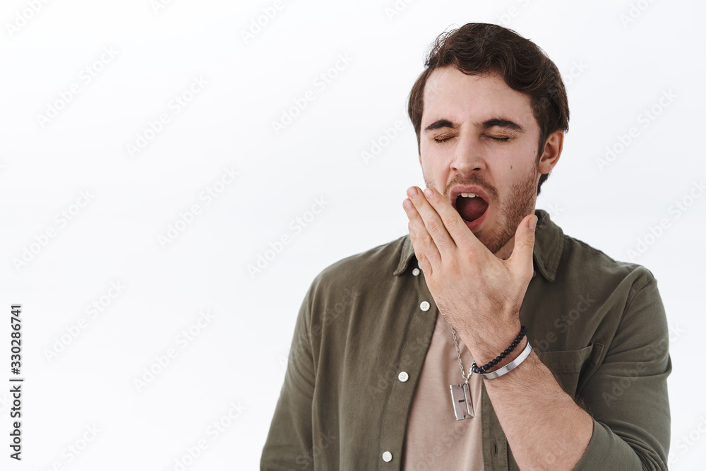 Close-up portrait of bored and tired, sleepy young guy feel uninterested, unamused at boring conference, yawn with closed eyes and cover opened mouth, wake-up early morning, white background Close-up portrait of bored and tired, sleepy young guy feel uninterested, unamused at boring conference, yawn with closed eyes and cover opened mouth, wake-up early morning, white background