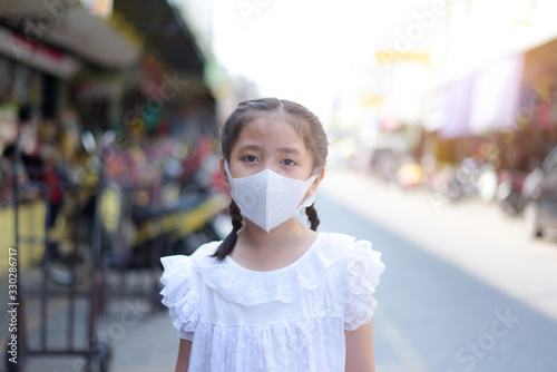 Asian girl wearing protective face mask Protect from the corona virus or Coronavirus covid-19.or Air pollution with market blurred background.