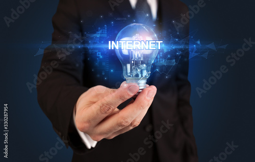 Businessman holding light bulb with INTERNET inscription  innovative technology concept