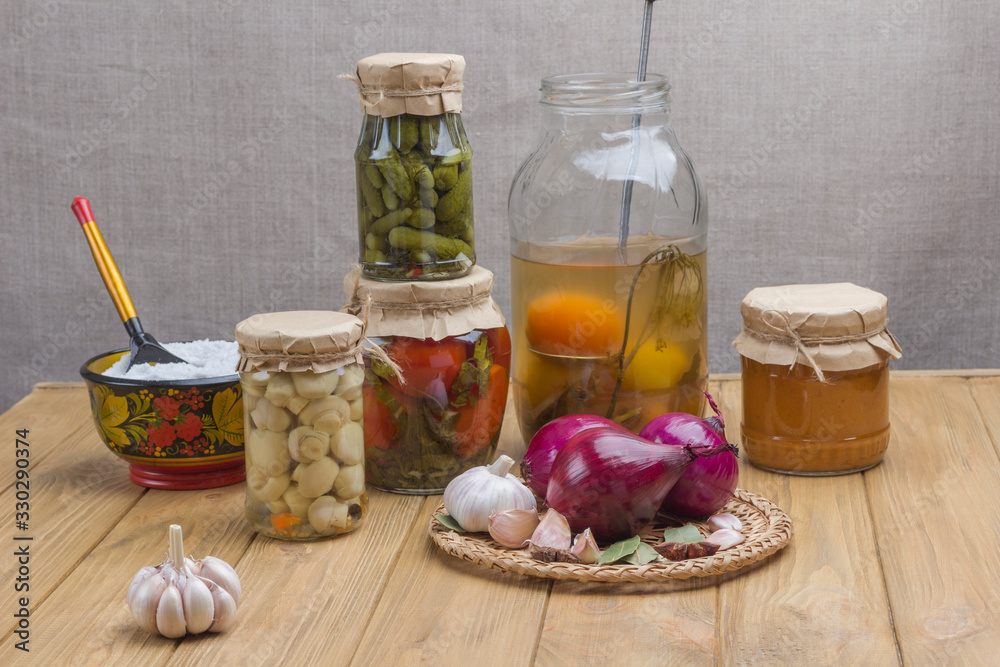 Glass jars with canned vegetables. Spice: salt, garlic, onion, bay leaf on table Glass jars with canned vegetables. Spice: salt, garlic, onion, bay leaf on table