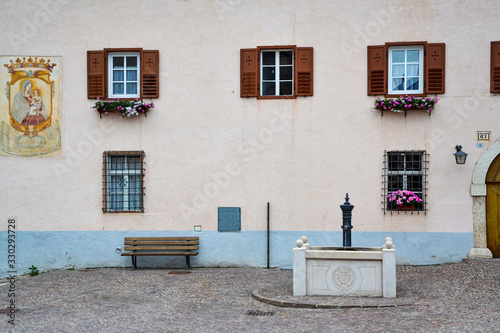 piazza con panchina fontana e finestre