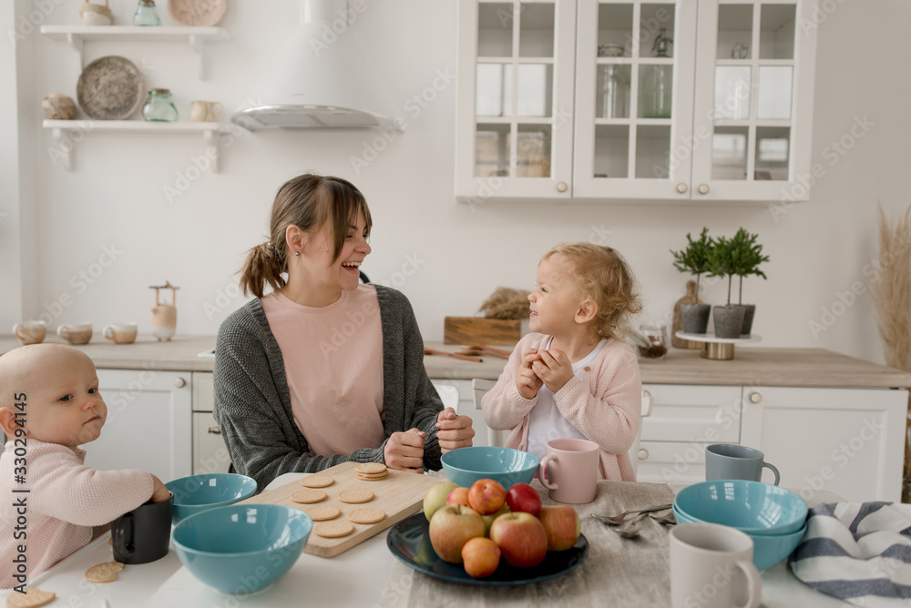 A young mother spends time with her little daughters at home.