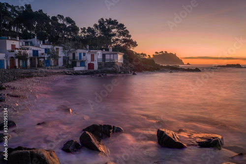 Vista de un pueblo de pescadores al amanecer en la costa Brava con el mar en calma