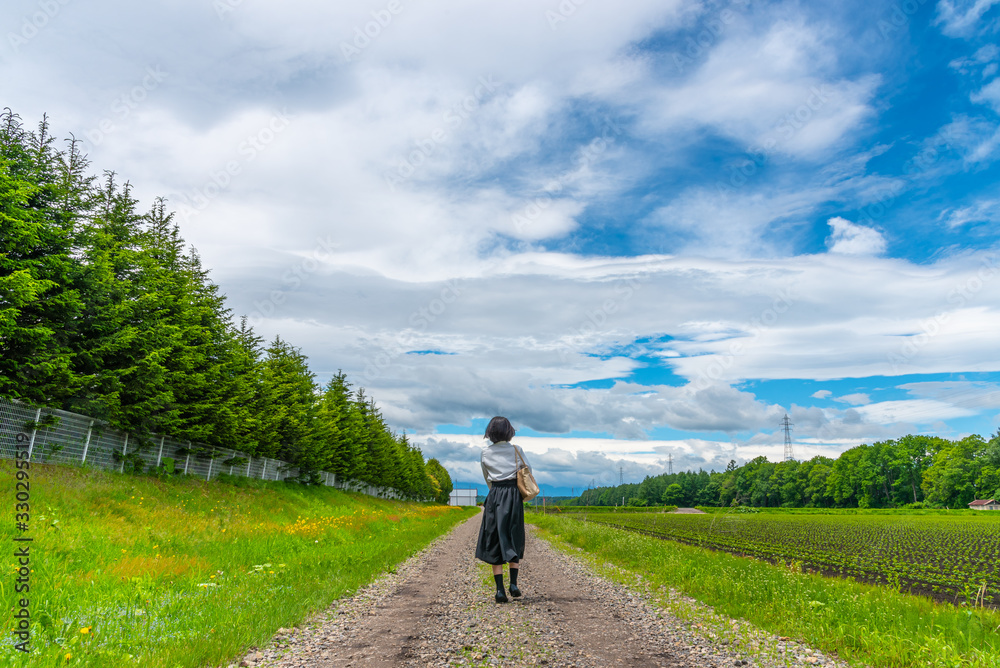 Young asian girl walking on a country road in sunny day