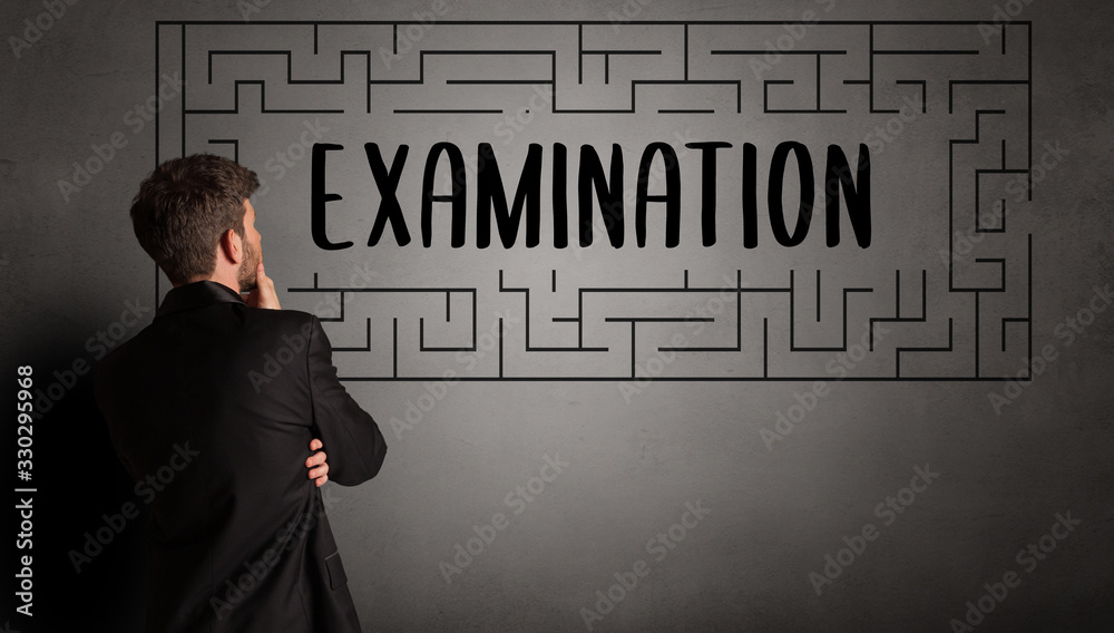 businessman drawing maze with EXAMINATION inscription, business education concept