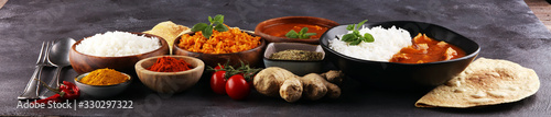 Chicken tikka masala spicy curry meat food in pot with rice and naan bread. indian food on table