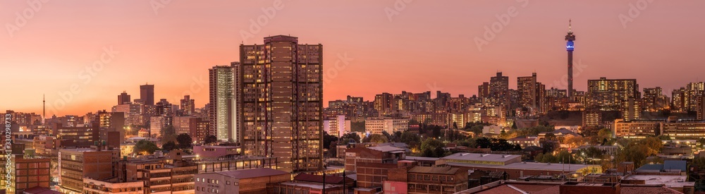 Fototapeta premium Piękne i dramatyczne zdjęcie panoramiczne panoramy miasta Johannesburg wykonane w złoty wieczór po zachodzie słońca.