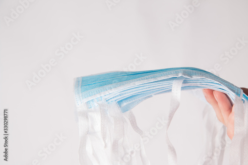 Some blue medical face masks to prevent coronavirus with white background © Ina
