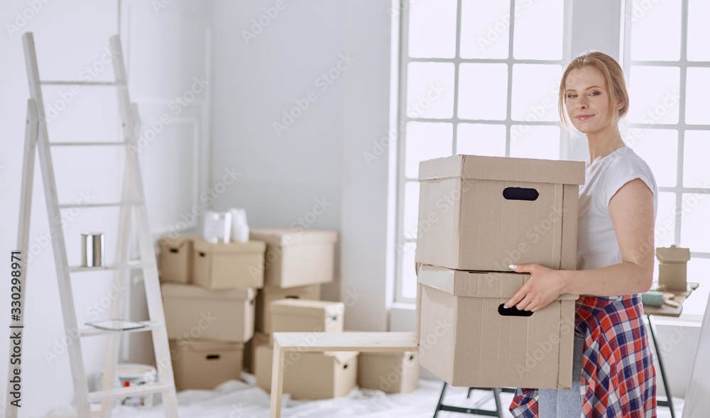 A beautiful single young woman unpacking boxes and moving into a new home A beautiful single young woman unpacking boxes and moving into a new home