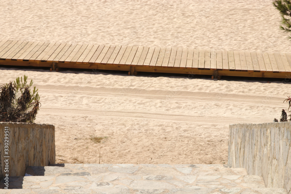 Steps down to the beach and a boardwalk on the sand Steps down to the beach and a boardwalk on the sand