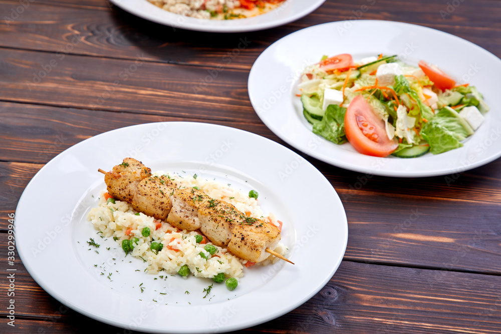 chicken kebab with rice and vegetables on the wooden background chicken kebab with rice and vegetables on the wooden background