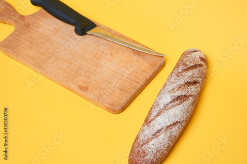 Bread on cut board. Fresh bread on the kitchen table. The healthy eating and traditional bakery concept.