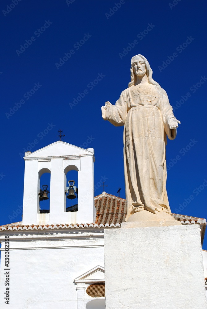 View of Our Lady of Remedies hermitage with a statue in the foreground, Velez Malaga, Spain.