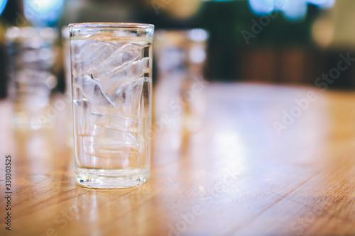 Cold glass of water with ice on wooden at restaurant.from which the fresh and pure water. Concept: nature, purification, freshness.