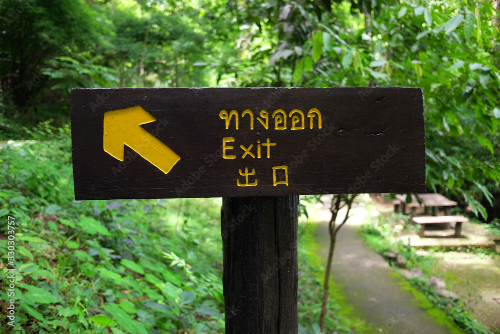 Exit Wooden label in National forest there are three languages is Thai, English and Chinese alphabets for foreign tourists in Thailand