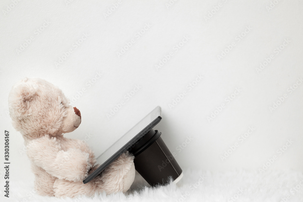 Teddy bear with a digital tablet and smartphone on a white background Teddy bear with a digital tablet and smartphone on a white background